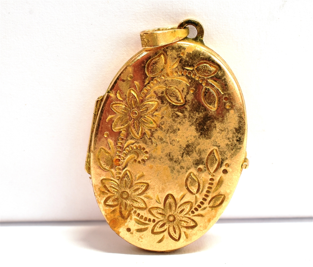 A FLORAL ENGRAVED PHOTO LOCKET The oval yellow metal locket with bale stamped 375, measuring 2.8cm x