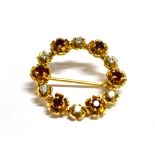 A DIAMOND AND RUBY CIRCLE BROOCH The brooch set with six round cut rubies (0.3cm) and six round