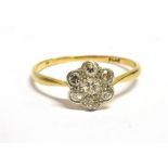 AN ART DECO DAISY DIAMOND RING The ring set with seven old cut diamonds, the central diamond