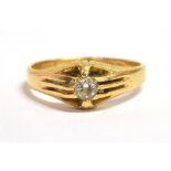 AN 18CT GOLD CLEAR PASTE SOLITAIRE RING The ring with textured shoulders on a tapered yellow gold