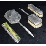 AN ART DECO SILVER DRESSING TABLE SET comprising a silver backed mirror 31cm in length, a silver