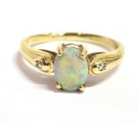 A 9CT GOLD OPAL DRESS RING The ring set with a single opal measuring 0.8cm X 0.6cm with a white