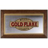 A WILLS'S GOLD FLAKE CIGARETTES ADVERTISING MIRROR in its original oak frame, overall 26cm x 51cm (