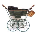 A DOLL'S PRAM late 19th or early 20th century, the lined green wood body with a folding hood and a