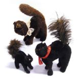 THREE SOFT TOY BLACK CATS circa 1930s, each with an arched back and raised tail, the largest 24cm