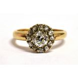 AN ART DECO DAISY DIAMOND RING The ring set with a European cut central diamond, measuring approx