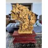 A LARGE ORIENTAL HARDWOOD SCULPTURE with deep relief carving depicting five warriors on horseback,