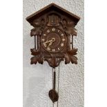 A BLACK FOREST CUCKOO CLOCK in carved wooden case
