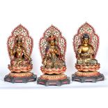 A GROUP OF THREE CARVED WOODEN FIGURES OF DEITIES polychrome enamelled with gilt highlights, each