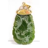 A VINTAGE 9CT GOLD MOUNTED JADE PENDANT PIECE The carved spinach Jade pendant with 9ct gold scroll