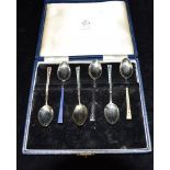 A CASED SET OF SIX SILVER AND ENAMEL TEASPOONS the six teaspoons with coloured enamel to the front