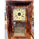AN AMERICAN WALL CLOCK in walnut case, paper trade label for 'E N WELCH', 39cm wide 66cm high