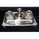 A SILVER PLATED COPPER DOUBLE INKWELL AND CANDLE HOLDER STAND The stand on four feet with shell