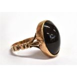 A 9CT GOLD GARNET GLASS BOULE RING The stone measuring 1.5cm x 1.1cm the shank with 9.375 marking,