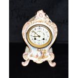 A FRENCH ROCOCO STYLE MANTLE CLOCK The gilt highlighted porcelain case polychrome enamelled with a
