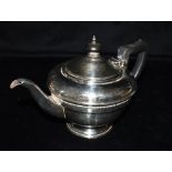 A SILVER TEAPOT The teapot of plain form with beaded trim to the middle, ebonised handle and knob,