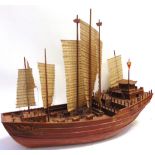 A MODEL OF A CHINESE JUNK of wooden construction, in full sail, 91cm long. Condition Report :