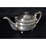 EARLY 19TH CENTURY SILVER TEA POT The teapot with Angled handle and four ball feet, patterned