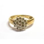 A 9CT GOLD DIAMOND CLUSTER RING the tiered cluster measuring 1cm in diameter, depth 0.5cm, the