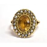 A STAMPED 9CT CITRINE AND SEED PEARL CLUSTER RING The oval Citrine measuring 1.1cm X 0.8cm in a seed