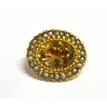 A CITRINE AND SEED PEARL BROOCH The brooch set with an oval Citrine measuring 1.5cm X 1cm in a