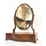 A MAHOGANY DRESSING TABLE MIRROR with oval glass, the serpentine front base fitted with three
