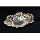 A LATE VICTORIAN SILVER PIERCED BASKET The basket on four ball feet with heart and ribboned bow