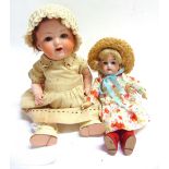 TWO BISQUE DOLLS comprising an Armand Marseille bisque socket head doll, with a cropped brown wig,