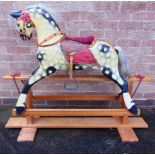 A CARVED WOOD ROCKING HORSE probably by Collinson, the slightly side glancing head with a horse-hair