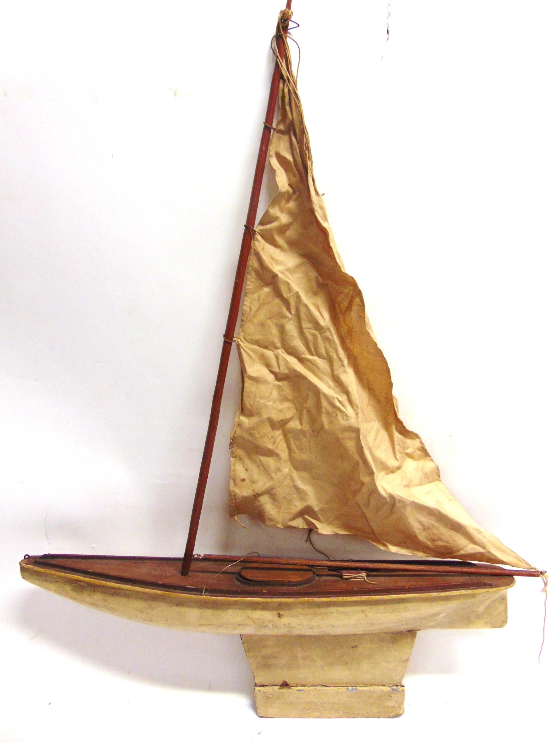 A POND YACHT of wood construction, with a plank-effect deck, cream painted hull, and a weighted