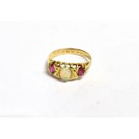 AN OPAL AND RUBY THREE STONE RING the ring centrally set with an oval precious opal measuring 6 x