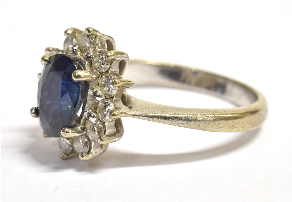 A STAMPED 750 DIAMOND AND SAPPHIRE CLUSTER RING the facetted oval blue sapphire measuring 9 x 6mm - Image 3 of 4