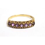 A GOLD, PURPLE GARNET SEVEN STONE DRESS RING Faded London hallmark, ring size T, weight 2.2g. NB