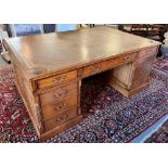 A GOOD QUALITY REPRODUCTION OAK PARTNERS DESK with gilt tooled leather inset top, fitted with pair