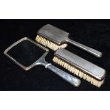 A SILVER BACKED MIRROR AND TWO PIECE BRUSH SET the three items all in engine turned silver,