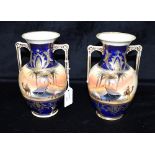 A PAIR OF NORITAKE TWIN-HANDLED VASES hand painted with desert landscapes, Bedouins and camels, 18.