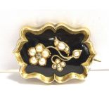 A VICTORIAN SEED PEARL AND ENAMEL MEMORIAL BROOCH the brooch in black enamel, featuring a floral