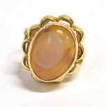 A STAMPED 18K MIDDLE EASTERN AQEEQ STONE RING the oval aqeeq stone, orange in colour with light grey