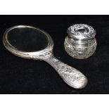 A VICTORIAN SILVER BACKED MIRROR TOGETHER WITH A SILVER LIDDED GLASS JAR The mirror heavily embossed