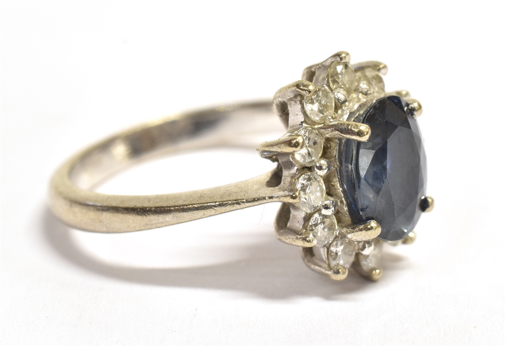 A STAMPED 750 DIAMOND AND SAPPHIRE CLUSTER RING the facetted oval blue sapphire measuring 9 x 6mm - Image 2 of 4