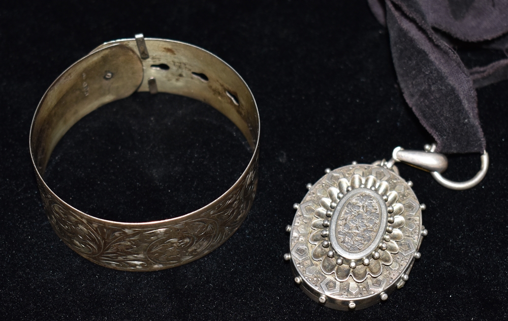 A RETRO SILVER BANGLE together with a Victorian white metal locket, the silver bangle fashioned as a