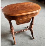 A VICTORIAN WALNUT SEWING TABLE with carved decoration, the oval top 60cm x 40cm opening to fitted