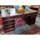 A REPRODUCTION PARTNERS DESK with green tooled leather inset top, fitted to each side with three