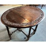 AN OAK GATELEG TABLE with carved decoration, the oval top 108cm x 127cm Condition Report : generally