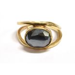 A SMOKEY QUARTZ SOLITAIRE RING The ring horizontally set with a faceted oval quartz stone