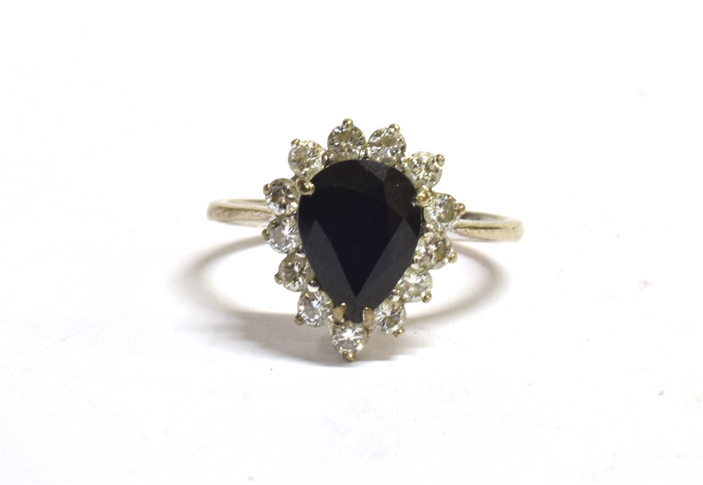 A STAMPED 18CT DIAMOND AND SAPPHIRE CLUSTER RING the facetted pear shaped sapphire measuring 10 x