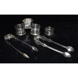 A COLLECTION OF SILVER two pairs of silver sugar nips together with four assorted silver napkin