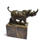 A CAST FIGURE OF A STANDING RHINOCEROUS on a rectangular flecked marble plinth Height 19cm, width