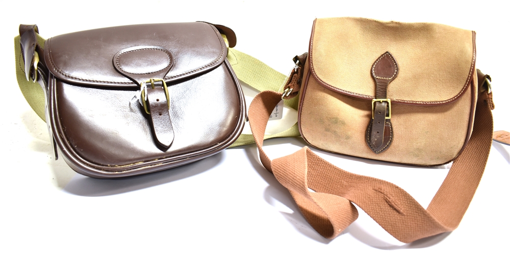 A BROWN LEATHER CARTRIDGE BAG with canvas shoulder strap, width 26cm and a canvas cartridge bag with