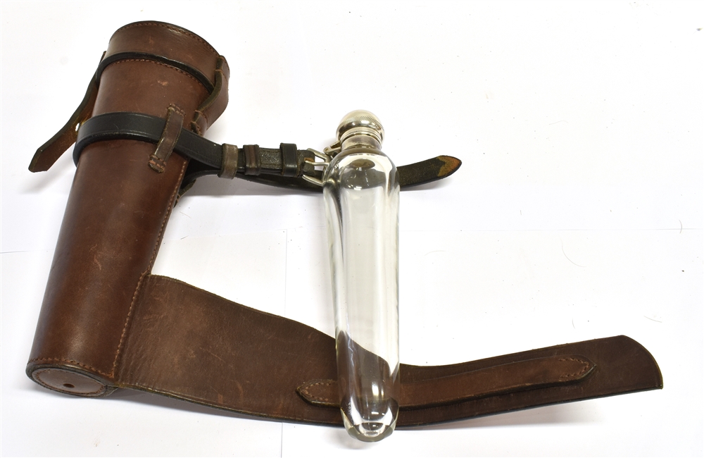 A TAPERED GLASS FLASK with plated flip top in leather holder for saddle mounting, 23cm